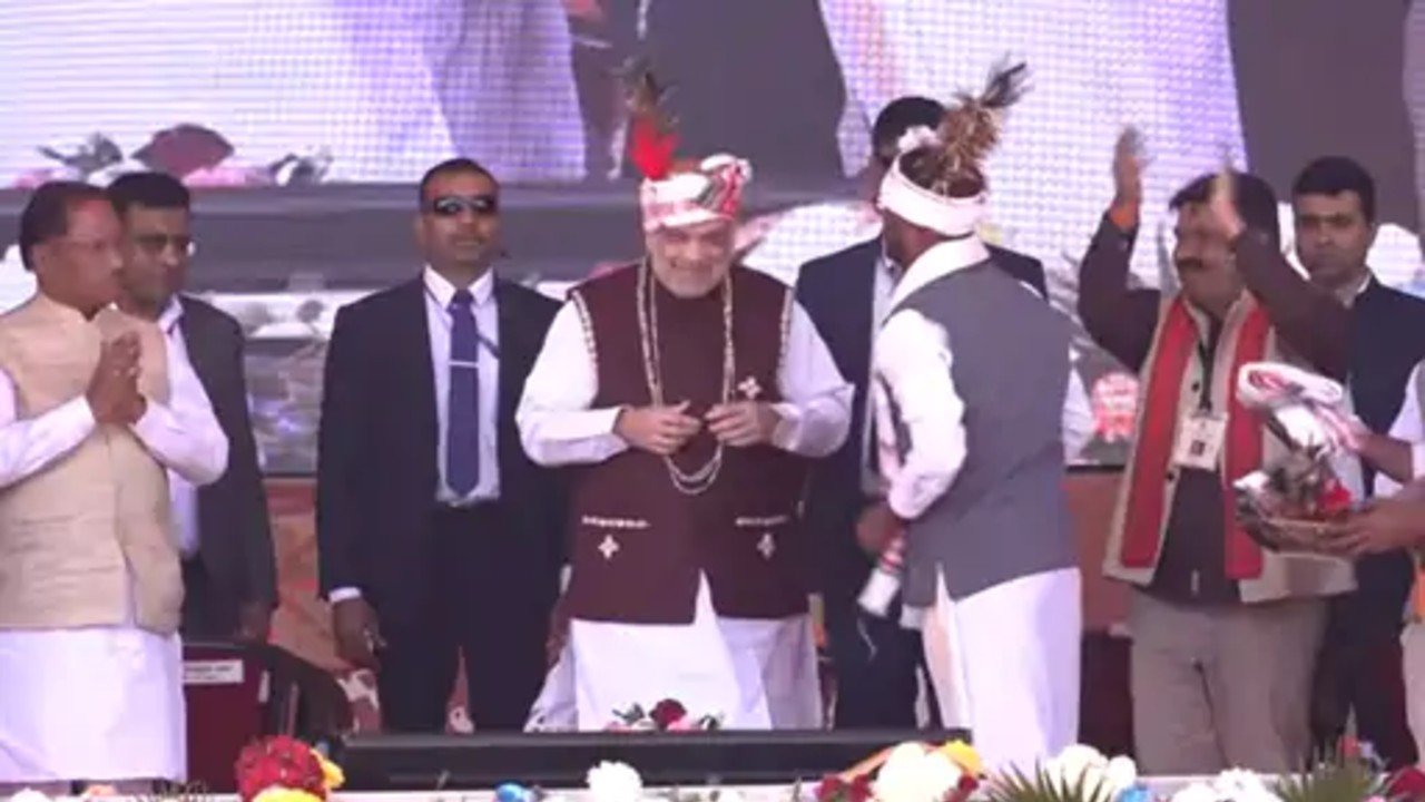 Chhattisgarh News: बस्तर पडुंम में शामिल हुए अमित शाह, पहनाई गई कौड़ी की माला और पारंपरिक पगड़ी